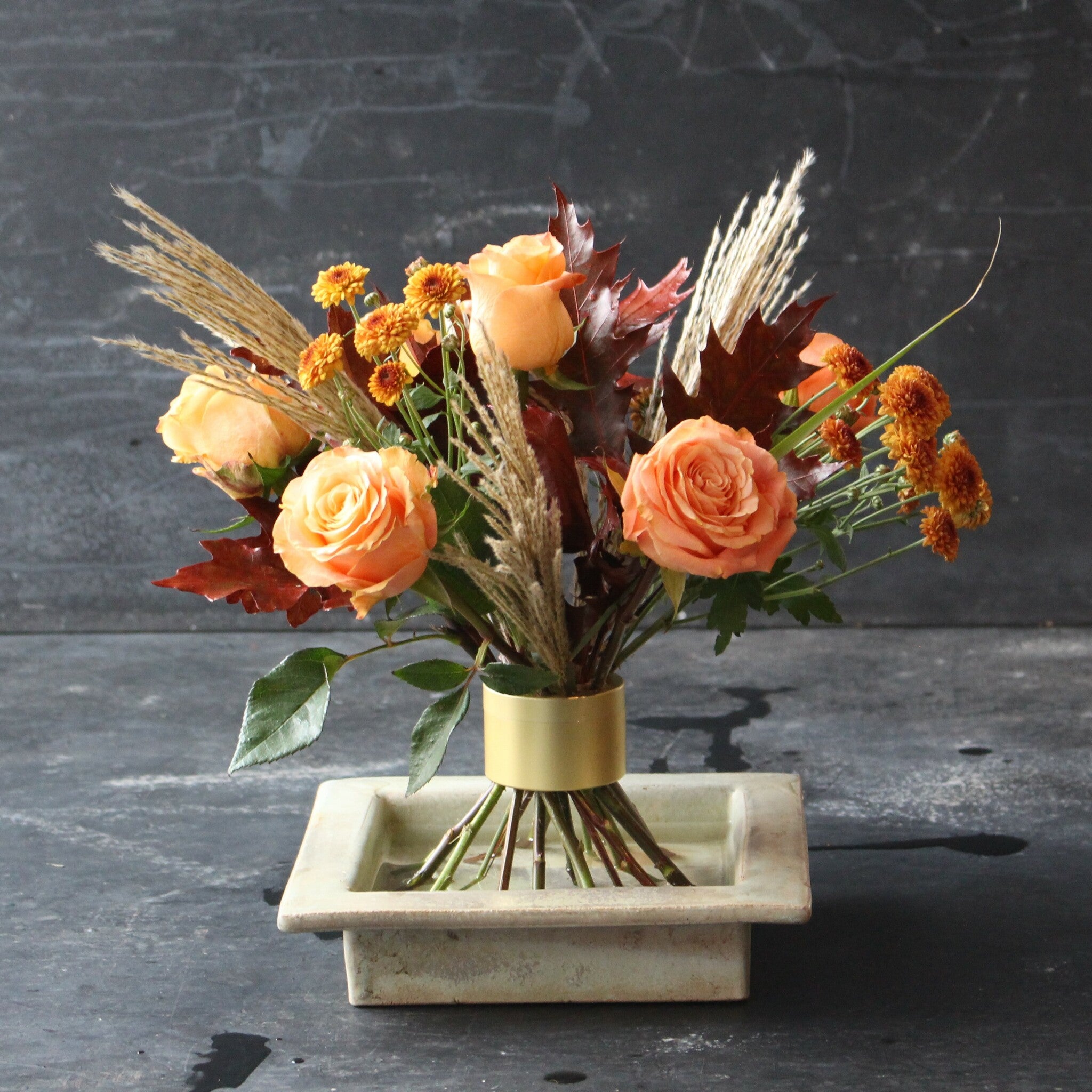 Autumnal Ikebana arrangement with orange roses and seasonal foliage using a Hanataba Champagne Gold Spiral Stem holder.